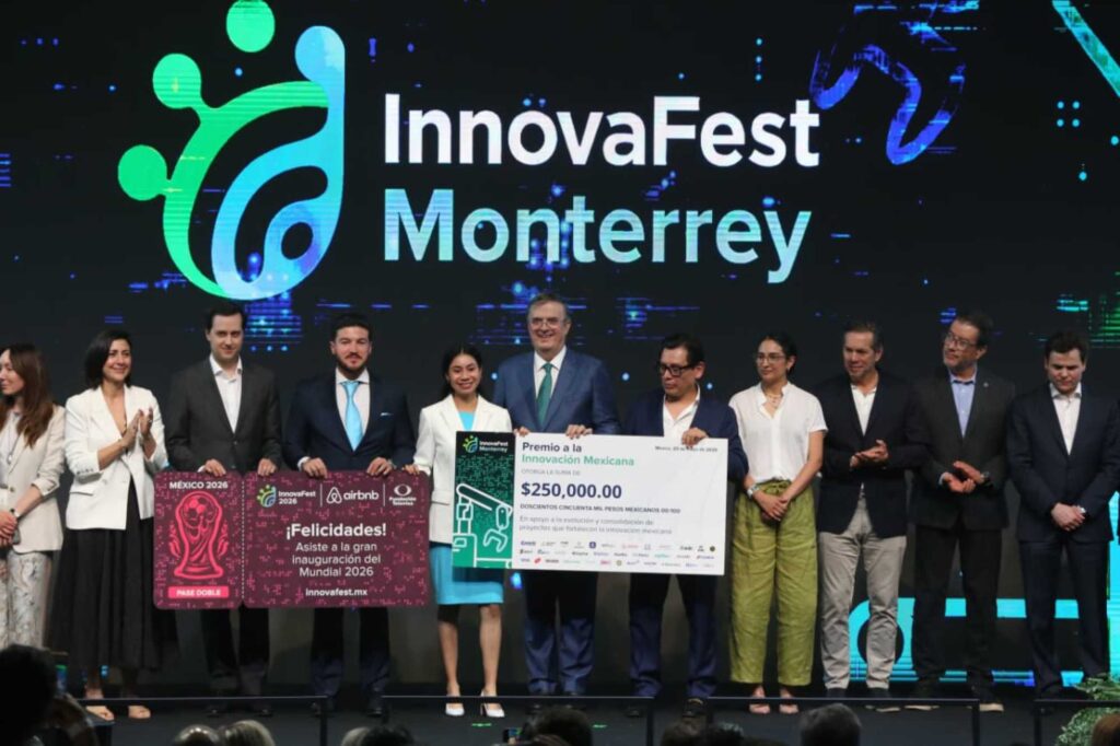 Group of award winners on stage holding oversized checks at Innovafest Monterrey ceremony