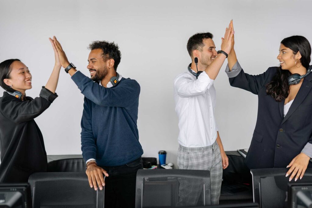 Colaboradores conversan y celebran en la oficina como parte de una cultura de amistad en el trabajo y bienestar laboral.