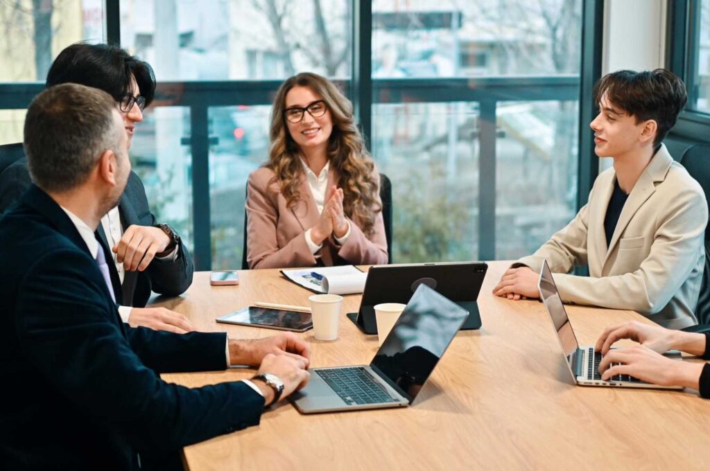 Equipo de trabajo en reunión revisa acuerdos y responsables para evitar la juntitis y mejorar la productividad.