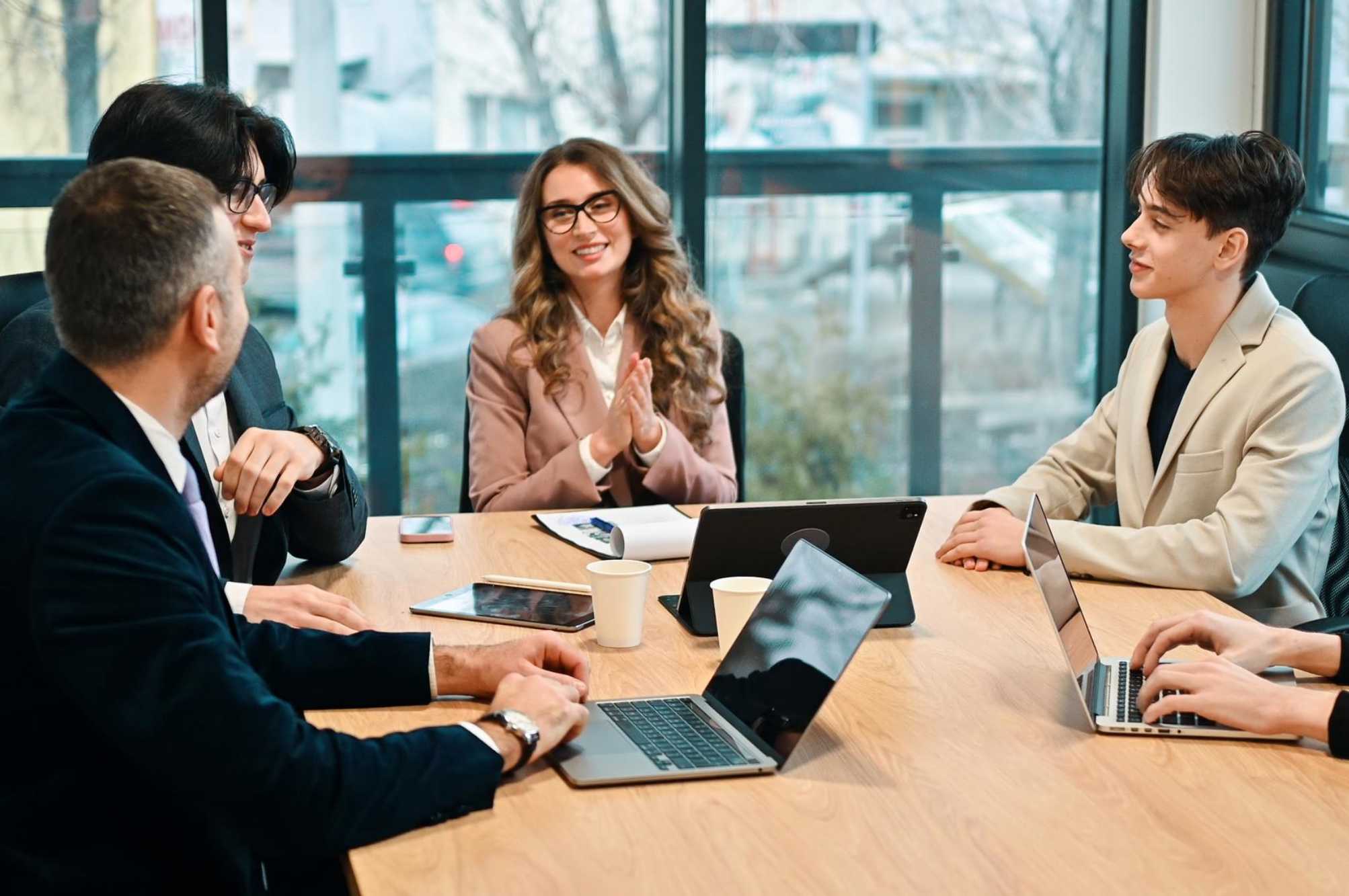 Equipo de trabajo en reunión revisa acuerdos y responsables para evitar la juntitis y mejorar la productividad.