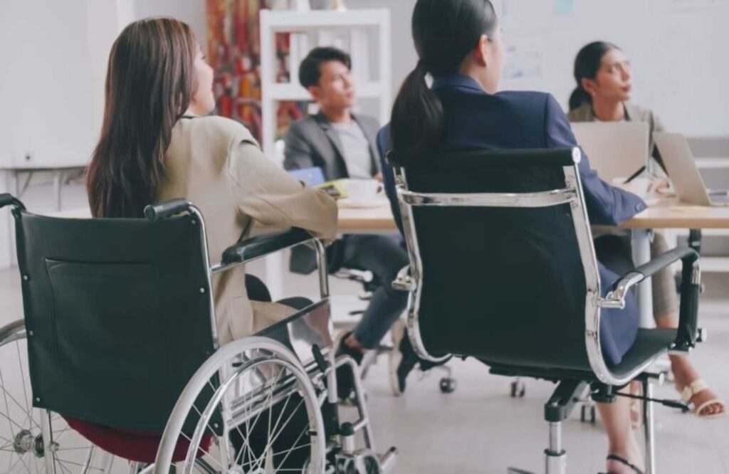 Mujer con discapacidad trabaja en oficina como parte de una estrategia de inclusión laboral y autonomía económica.