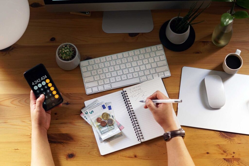 Persona organiza su dinero entre gastos, ahorro, deudas y metas financieras para planear mejor sus ingresos.